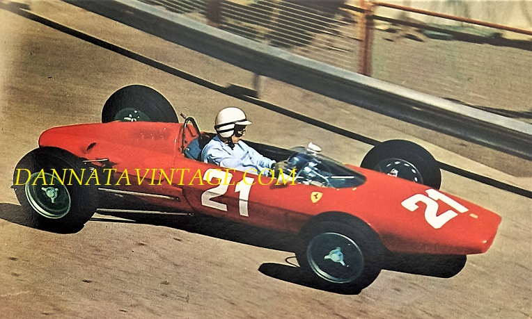 Si correva, John Surtees alla guida di una Ferrari prima di affrontare la Curva del Tabaccaio al GP di Monaco del 1963, era la sua prima gara su una auto dopo aver abbandonato le moto da campione del mondo. Motore posteriore da sei cilindri a V 1476 Cc e 210 cavalli a 10.200 la potenza.